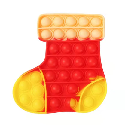 The Rainbow Pop Fidget Stress Toy by FidgetFuns, shaped like a Christmas stocking, offers sensory satisfaction. With a yellow top and heel and red body and toe, this tool features bubble-like buttons for pressing, providing stress relief for a calm moment.