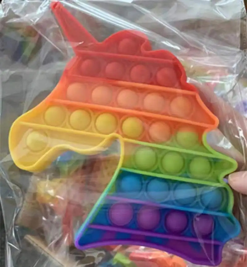 The Rainbow Pop Fidget Stress Toy by FidgetFuns, shaped like a unicorn and partly encased in clear plastic, promises sensory satisfaction with vibrant bubbles in red, orange, yellow, green, blue, and purple rows for ultimate stress relief.